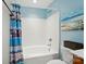 Cozy bathroom features a tub with blue patterned shower curtain and a beach-themed painting at 541 River Park Rd, Belmont, NC 28012