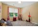 Cozy room featuring a gray futon, decorative chair, and window with patterned curtains at 541 River Park Rd, Belmont, NC 28012