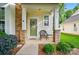 Inviting front porch showcasing stone pillars, decorative wreath on the door, and a cozy seating arrangement at 541 River Park Rd, Belmont, NC 28012