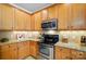 Bright kitchen with wood cabinets, stainless appliances, stone countertops, and tile backsplash at 541 River Park Rd, Belmont, NC 28012