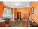 Bright living room featuring orange walls, hardwood floors, a large window, and stylish furnishings at 541 River Park Rd, Belmont, NC 28012