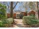 A brick house with a walk-out deck is surrounded by lush greenery and trees in the backyard at 5550 Monticello Nw Dr, Concord, NC 28027