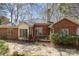 Exterior view of a brick home showcasing a wooden deck, and a lush, inviting backyard at 5550 Monticello Nw Dr, Concord, NC 28027