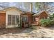 Backyard featuring a small wooden deck with stairs, a brick exterior, and an array of windows at 5550 Monticello Nw Dr, Concord, NC 28027