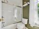 This bathroom features a shower-tub combo with glass doors, a neutral toilet, and bright lighting at 5716 Trimmings Ct, Charlotte, NC 28226