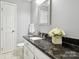 Bathroom featuring a granite countertop, white cabinets, and modern fixtures at 5716 Trimmings Ct, Charlotte, NC 28226