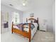 This bright bedroom boasts natural light, complemented by neutral decor, hardwood furniture, and soft textures at 5716 Trimmings Ct, Charlotte, NC 28226