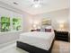 This light-filled bedroom features a large window, neutral decor, and comfortable furnishings at 5716 Trimmings Ct, Charlotte, NC 28226
