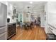 Bright dining room featuring wood floors, a modern light fixture, and a view into the living room at 5716 Trimmings Ct, Charlotte, NC 28226