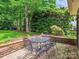 A backyard patio featuring brick accents and metal seating, ideal for enjoying outdoor dining and entertaining guests at 5716 Trimmings Ct, Charlotte, NC 28226