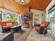 Relaxing screened porch with brick fireplace, TV, and wicker furniture, perfect for outdoor entertainment and enjoyment at 5716 Trimmings Ct, Charlotte, NC 28226
