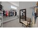 Walk-in closet with ample shelving, hanging racks, a full length mirror and a decorative chair at 7010 Brush Crk, Monroe, NC 28110