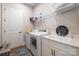 Well-organized laundry room with white washer, dryer, and sink with plentiful storage and wire shelving at 7010 Brush Crk, Monroe, NC 28110