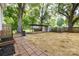 Large fenced backyard with mature trees and a storage shed at 80 Pine St, Badin, NC 28009