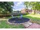 Cozy backyard featuring a stone fire pit, surrounded by garden beds, chairs, and a wooden privacy fence at 80 Pine St, Badin, NC 28009
