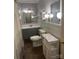 Updated bathroom featuring a gray vanity, new toilet, and marble-topped shelving unit at 80 Pine St, Badin, NC 28009