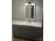 Bathroom vanity with a white sink, gray cabinets and a large mirror with decorative light fixture at 80 Pine St, Badin, NC 28009