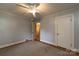 A simple bedroom features carpet flooring, neutral paint, a ceiling fan, and closet space at 80 Pine St, Badin, NC 28009