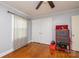 A simple bedroom features hardwood floors, a ceiling fan, and closet space at 80 Pine St, Badin, NC 28009