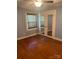 This bedroom features wood floors, natural light, and glass paneled doors at 80 Pine St, Badin, NC 28009