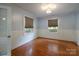 Charming bedroom featuring light blue walls, hardwood floors, two windows with neutral blinds, and white trim at 80 Pine St, Badin, NC 28009
