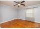 A simple bedroom features hardwood floors, a ceiling fan, neutral paint, and natural light at 80 Pine St, Badin, NC 28009
