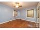 Serene bedroom features two windows, a ceiling fan, a closet with mirror doors and beautiful hardwood floors at 80 Pine St, Badin, NC 28009