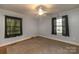 A simple bedroom features carpet flooring, neutral paint, and lots of natural light at 80 Pine St, Badin, NC 28009