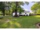 Single-story home featuring a lush green lawn, mature tree, and brick-lined garden bed at 80 Pine St, Badin, NC 28009
