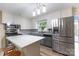 Bright kitchen boasts modern stainless steel appliances, gray countertops, and wood-look flooring for a stylish look at 80 Pine St, Badin, NC 28009