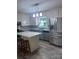 This kitchen features stainless steel appliances, an island, and gray lower cabinets at 80 Pine St, Badin, NC 28009