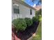 Landscaped side yard with meticulously arranged mulch and shrubs at 80 Pine St, Badin, NC 28009