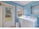 Laundry room with light blue walls and appliances overlooking the backyard at 80 Pine St, Badin, NC 28009
