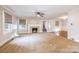 Spacious living room with fireplace, windows, neutral carpet, ceiling fan, and open doorway at 80 Pine St, Badin, NC 28009