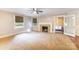 Bright living room featuring neutral walls and carpet, fireplace, ceiling fan, and open doorway at 80 Pine St, Badin, NC 28009