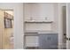 A charming mudroom features white cabinets, gray countertops and convenient access to an adjacent half-bath at 80 Pine St, Badin, NC 28009