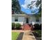 Charming single-story home featuring manicured bushes and brick stairs leading to the front door at 80 Pine St, Badin, NC 28097