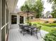 Outdoor deck with shaded dining area and lush, landscaped backyard at 8105 Rachel Ct, Waxhaw, NC 28173
