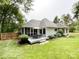 Expansive backyard with patio dining, manicured lawn, and mature trees at 8105 Rachel Ct, Waxhaw, NC 28173
