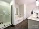 Clean bathroom with a walk-in shower, a soaking tub, and white tile at 8105 Rachel Ct, Waxhaw, NC 28173