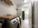 Laundry room with washer and dryer with wooden countertop, and doorway to the kitchen at 8105 Rachel Ct, Waxhaw, NC 28173