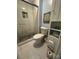A well-lit bathroom features a glass shower, a toilet, and built-in shelves for storage at 8306 Knights Bridge Rd, Charlotte, NC 28210