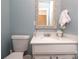 Well-lit half bathroom with white vanity and decorative mirror at 8306 Knights Bridge Rd, Charlotte, NC 28210