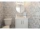 Charming bathroom with floral wallpaper, a round mirror, and a white vanity with modern fixtures at 8306 Knights Bridge Rd, Charlotte, NC 28210
