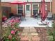 Back patio with outdoor seating, red umbrella, and lush landscaping at 8306 Knights Bridge Rd, Charlotte, NC 28210