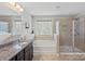 Well-lit bathroom with double vanity, soaking tub, and separate glass-enclosed shower at 8347 Dallas Bay Rd, Charlotte, NC 28278
