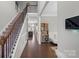 Inviting foyer with hardwood floors, staircase with iron railing, and a view into the living spaces at 8347 Dallas Bay Rd, Charlotte, NC 28278