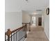 Neutral hallway with wood railings, carpet flooring, and a view of rooms beyond at 8347 Dallas Bay Rd, Charlotte, NC 28278