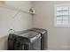 Modern laundry room equipped with a front-loading washer and dryer, alongside a wire shelf, creating convenience at 8347 Dallas Bay Rd, Charlotte, NC 28278