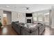 Cozy living room boasts a fireplace, large gray sectional, hardwood floors, and bright windows at 8347 Dallas Bay Rd, Charlotte, NC 28278